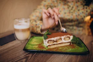 žena konzumuje tiramisu a kávu